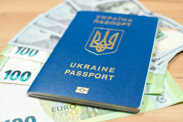 Ukrainian biometric passport id to travel the Europe with dollars and euros money on the table. Inscription in Ukrainian 