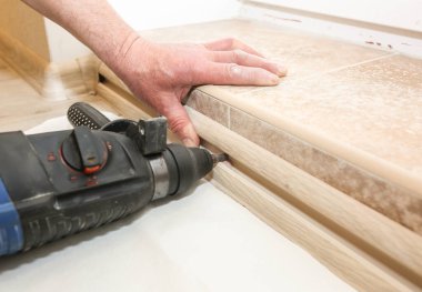 Kapıda kapı eşiği kurulumu. Elleri delin. Dairede tadilat yapılıyor..