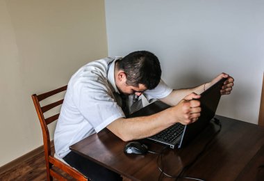 Beyaz gömlekli bir ofis çalışanı. Mesleki tükenmişlik. Kötü çalışma koşulları. Dizüstü bilgisayarlı mutsuz bir yönetici. Yaz sıcağı. Teslim tarihine yetişiyor. Masada stresli bir iş. Çaresiz adam..