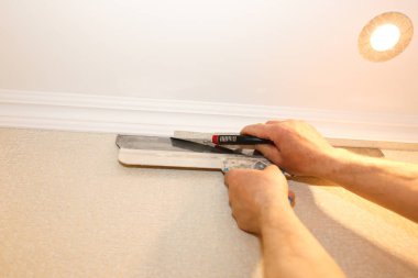 Adam duvar kağıdı kesiyor. Bakım onarımı dairede tadilat yapıyor. İçerideki restorasyon.