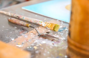 Ressamın gerçek çalışma stüdyosu. Sanatçı konsepti. Yaratıcı atmosfer. Boya palet bıçağı. Fırçalar.