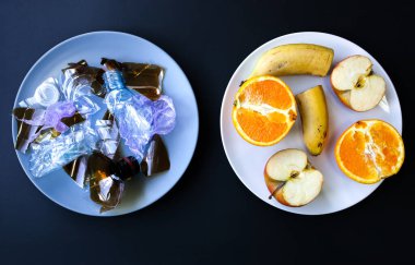 Plastik şişeler ve meyveler tabakta. Hayat tercihi. Kirli yiyecekler yiyen insanlar. Çevresel bir sorun. Ekolojik felaket. Geri dönüşüm sorunu.