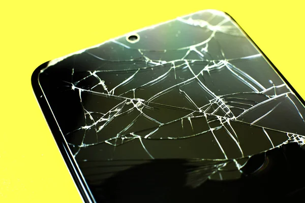 Broken tempered glass screen protector. Crashed smartphone. Close up.