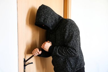 Kapının yanında demir levye olan bir suçlu. Hırsız eve giriyor..