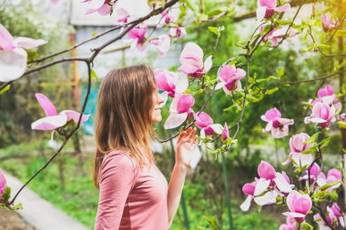 Çiçek açan ağacın yanında güzel bir kız. Açık havada manolya çiçeği. Bahar havası. Kadın dinleniyor..