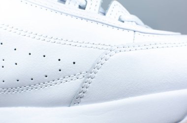 Modern spor ayakkabı arka planı. Beyaz deri ayakkabılar. Dikişler. Yaklaş. Doğal kumaşlar, tekstil malzemeleri..