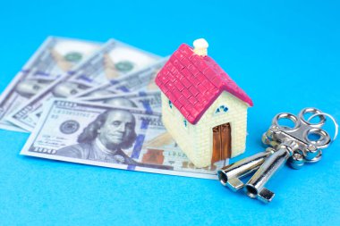 Ev, anahtarlar ve dolar. Emlak alıp kiralamak. Mülkiyet için banka kredisi. Para biriktir. Gelecekteki ev için yatırım yap.