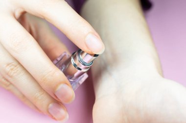 Woman applies perfume on her hand. Close up view