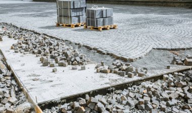 Eski kasabada yol çalışır. Yerde taşlar ve kaldırımlar var. Sokaklarda yeniden yapılanma. Kaldırım tamiri. Somut.