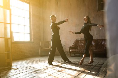 İki profesyonel balo dansçısı çatı katında dans ediyor. Güzel bir sanat gösterisi. Spor hayatı konsepti. Tutku ve duygusal dans.
