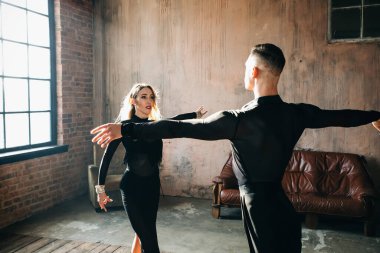 İki profesyonel balo dansçısı çatı katında dans ediyor. Güzel bir sanat gösterisi. Spor hayatı konsepti. Tutku ve duygusal dans.