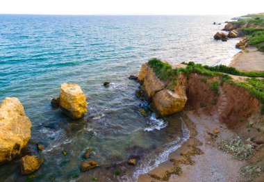Hava aracı fotoğrafı. Deniz kenarındaki İskandinav arazisindeki yeşil kayalık tepelerin güzel manzarası. Yeşil dağlar ve okyanus dalgaları. Seyahat ve seyahat kavramı. Şaşırtıcı doğa..