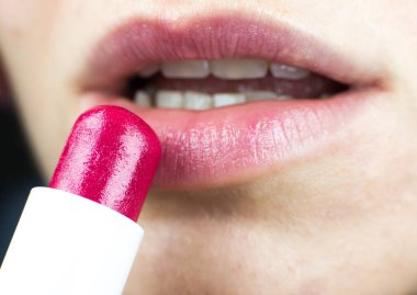 Genç bayan makyaj yapıyor. GIrl kırmızı veya pembe ruj sürer. Kapat..