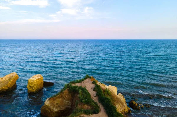 Hava aracı fotoğrafı. Deniz kenarındaki İskandinav arazisindeki yeşil kayalık tepelerin güzel manzarası. Yeşil dağlar ve okyanus dalgaları. Seyahat ve seyahat kavramı. Şaşırtıcı doğa..