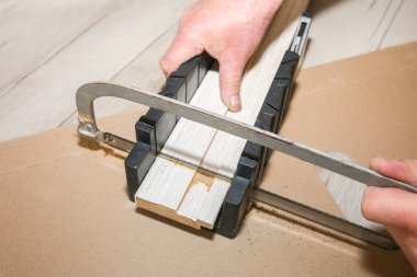 Man is installing the doors. Carpenter sawing wooden plank. Repair works. Maintenance in the apartment.