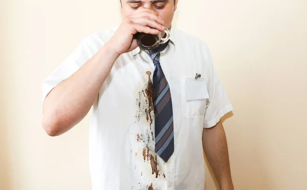 Office worker spills coffee on white shirt. Occupational burnout. Unhappy manager with mug in hands. Stressful job. Desperate man.