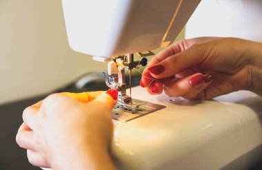 Kadın dikiş makinesine iplik koyuyor. Serbest çalışan kızlar ellerini kullanıyor. Moda konsepti. Yeni kıyafet süreci oluşturuluyor. Hobi fikirleri.