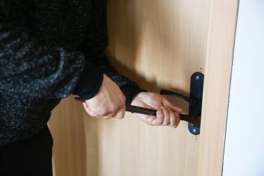 Kapının yanında demir levye olan bir suçlu. Hırsız eve giriyor..