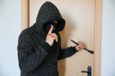 Kapının yanında demir levye olan bir suçlu. Hırsız eve giriyor..