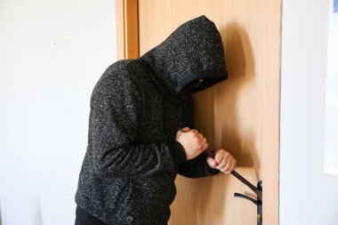 Kapının yanında demir levye olan bir suçlu. Hırsız eve giriyor..