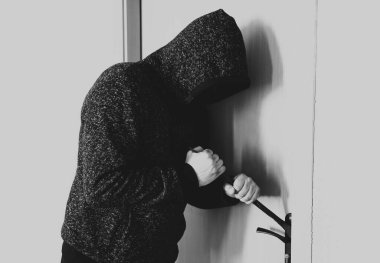 Kapının yanında demir levye olan bir suçlu. Hırsız eve giriyor..