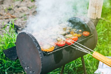 Dışarıdaki mangalda sebzeler. Yazın vejetaryen barbeküsü yanıyor. İyi eğlenceler. Doğada yemek pişirmek. Sağlıklı yaşam tarzı.