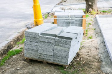 Eski kasabada yol çalışır. Yerde taş bloklar ve fayanslar var. Sokaklarda yeniden yapılanma. Kaldırım onarımı.