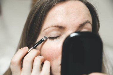 Kız makyaj yapıyor. Fırçayla göz farı. Güzellik fotoğrafı konsepti.