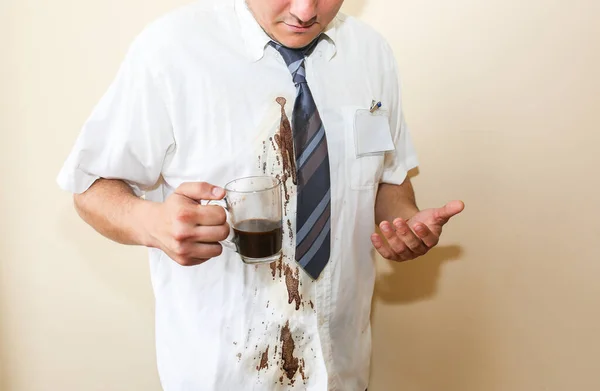 Office worker spills coffee on white shirt. Occupational burnout. Unhappy manager with mug in hands. Stressful job at the desk. Desperate man.