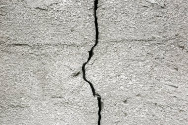 Concrete wall with a crack on it. Grey texture background.