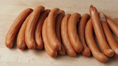 Thin long pork sausages on the wooden cutting board