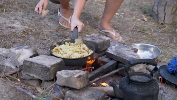Keittäminen paistettuja perunoita paistinpannulla kokko metsässä. 4K. Sulje se. — kuvapankkivideo