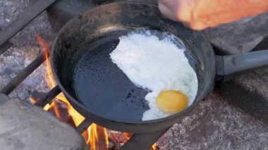 Erkek, Turist Kızarmış Yumurta Kızartması Kızartma Tavada Şenlik Ateşi Üzerinde. Kapat.