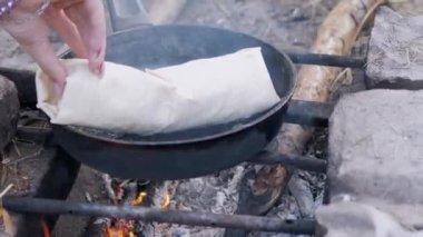 Pita on Outdoor 'da paketlenmiş et Shawarma hazırlama, Pan' da yanan şenlik ateşi.