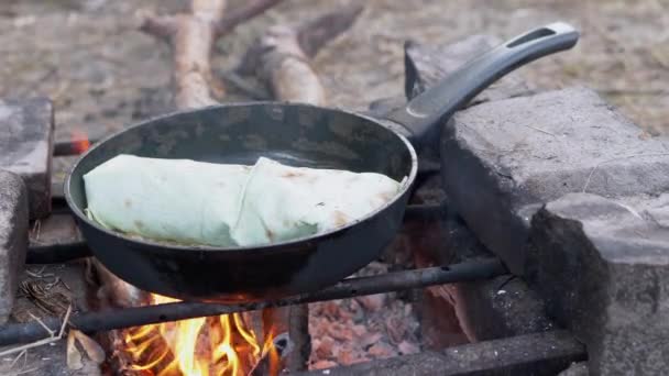 Cocinar carne Shawarma Envuelto en pan de Pita en abierto, hoguera ardiente, en Pan. 4K — Vídeo de stock