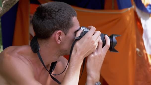 Joven fotógrafo Descansando cerca de tiendas Fotografías Paisajes en una orilla del río — Vídeos de Stock