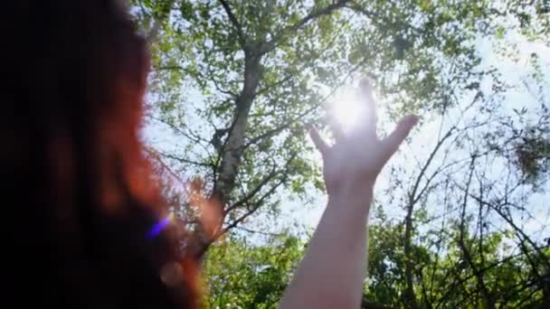 Egy boldog lány kezei elérik a napfényt naplementekor. Közelről. Lassú mozgás. — Stock videók