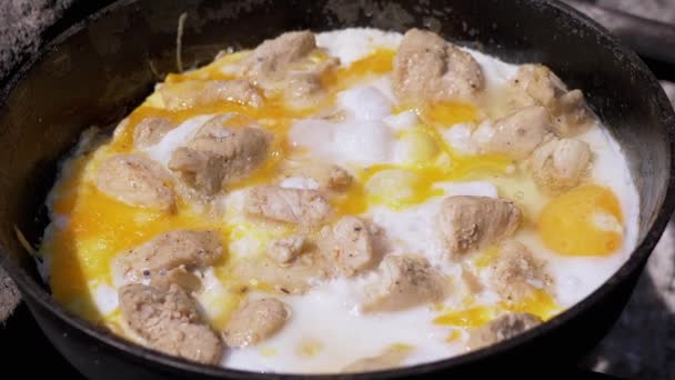 Préparation des œufs brouillés de viande dans une poêle sur le feu de joie. Zoom — Video