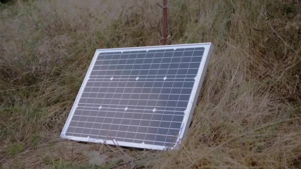 Jeden přenosný malý fotovoltaický solární panel nainstalovaný v trávě. 4K — Stock video