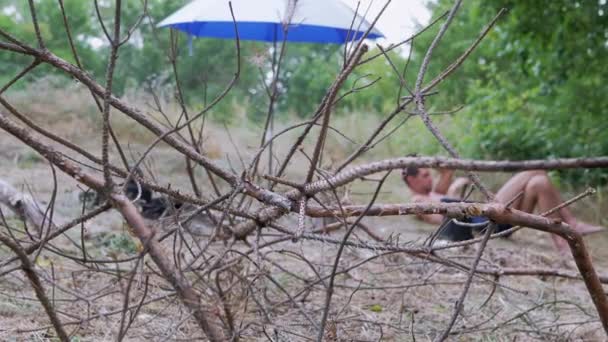 Torra grenar för ved Ligg i naturen mot bakgrund av en vilande turist — Stockvideo