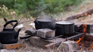 Açık havada, ormanda bir tencerede şenlik ateşinde yemek hazırlıyorum. 4 bin. Yavaş çekim