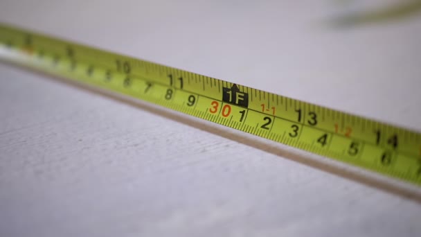 Plegar una cinta de centímetro con una doble escala de números en una cinta métrica — Vídeos de Stock