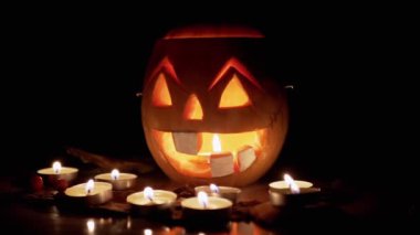 Korkunç Jack-o-Lantern yüzlü bir balkabağı, Karanlık Oda 'da yanan mumlar. Büyüt