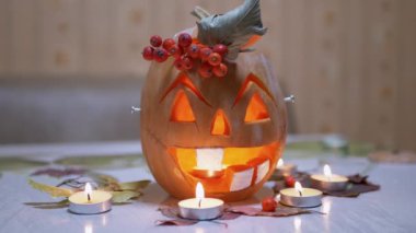 Jack Lantern 'in Gülen Suratı ve Odada Yanan Mumlar' la oyulmuş Balkabağı Kafa. 4K