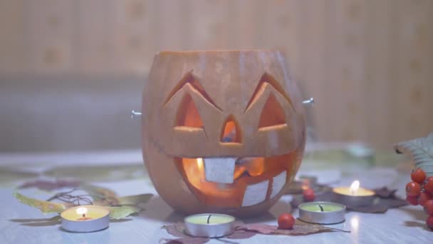 Cabeza de calabaza en humo con la cara sonriente de Jack Lantern, velas ardientes en la habitación — Vídeos de Stock