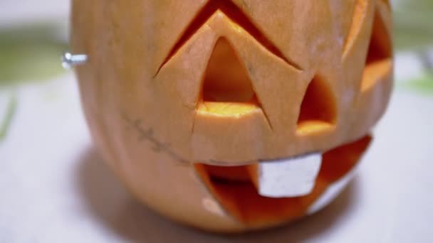 Jack Lantern Pumpkin Head with a Laughing Face Rotating on a Table in Room — Stock Video