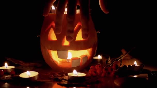 Kvindelige heksehænder tryller over brændende leder af Jack Lantern Pumpkin. Forstør – Stock-video