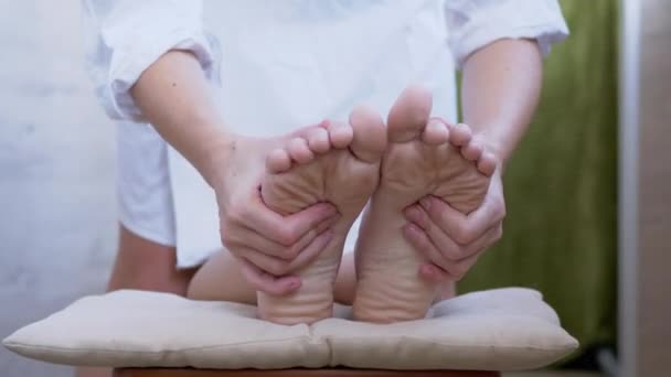 As mãos femininas estão massageando pernas nuas, pés, solas de uma criança. 4K. Fechar — Vídeo de Stock