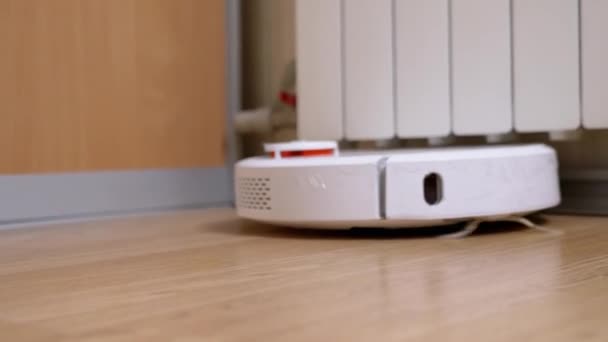 Una aspiradora automática moderna del robot barre los desechos en el piso en la habitación. De cerca. — Vídeos de Stock