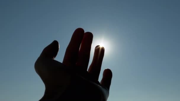 Mano femminile che gioca, tira ai raggi del sole, sole, cielo. 4K. Da vicino. — Video Stock